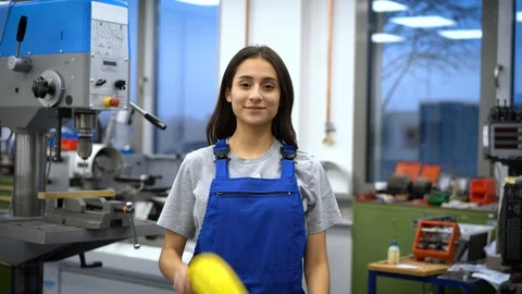 Smiling apprentice looking through yellow role of cables in factory Video stock 129375061