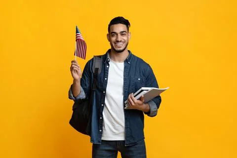 Smiling arab guy student showing flag of US Stock Photos