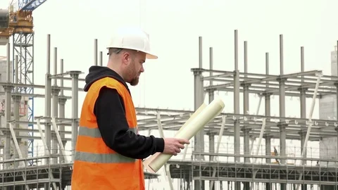 Smiling architect holding project in construction site Stock Footage 72324261
