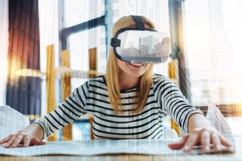 Smiling architect wearing virtual reality glasses and looking glad Stock Photos