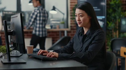 Smiling asian database software developer writing programming code on computer Stock Footage 168245420