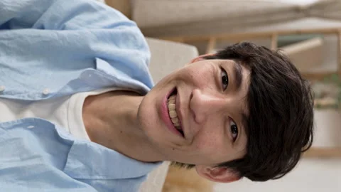 Smiling asian guy facing mobile phone cam Stock Footage 219397863
