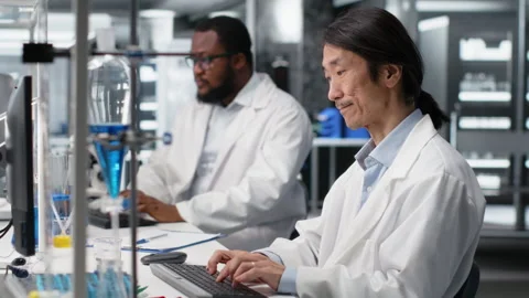 Smiling Asian laboratory researcher using computer to process DNA patient data Stock Footage 320144091