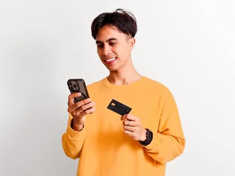 Smiling Asian man making digital payment transaction with credit card and s.. Stock Photos