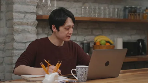 Smiling asian man studying at home. Stock Footage 153497828