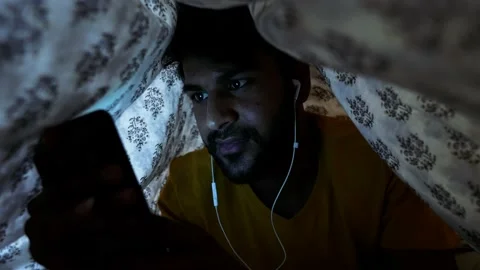 Smiling Asian Man Using Smart phone do chat while laying on bed at home indoo 스톡 동영상 154731862