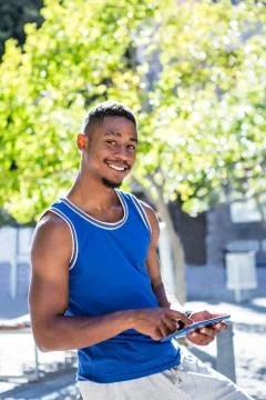 Smiling athletic man using tablet computer Stock Photos