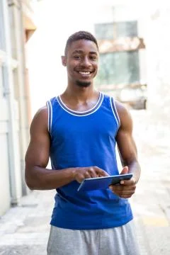 Smiling athletic man using tablet computer Stock Photos