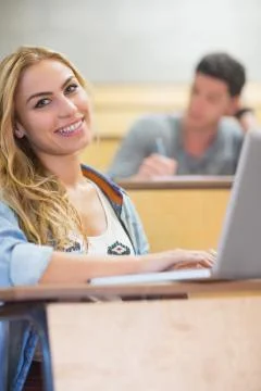 Smiling attractive student using laptop 스톡 사진