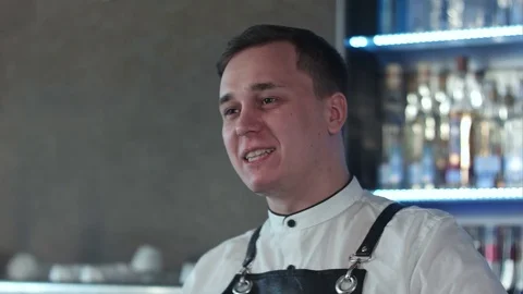 Smiling attractive young barman talking to client Vidéo 76596057