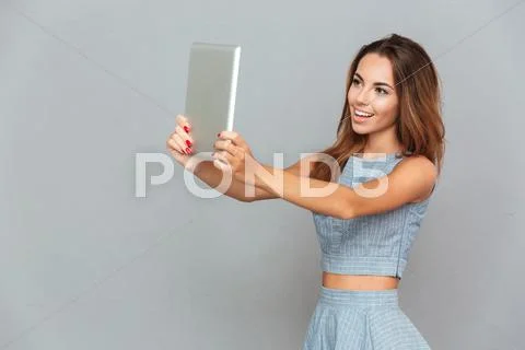 Smiling attractive young woman taking selfie with tablet Stock Photos