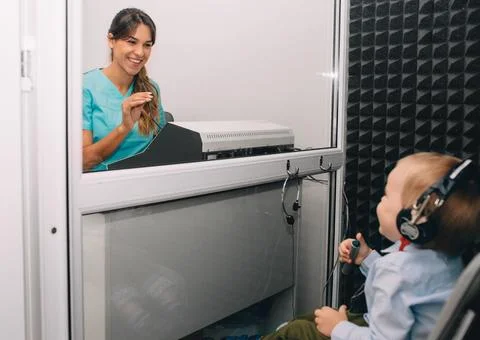 Smiling audiologist doing hearing test to little boy 写真素材