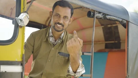 Smiling auto driver showing Ink marked finger after voting in election by Stock Footage 168681511