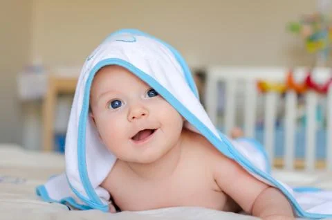 Smiling baby in a hooded towel after bath Stock Photos