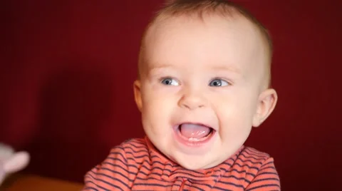 Smiling baby red background. Stock Footage 49499990