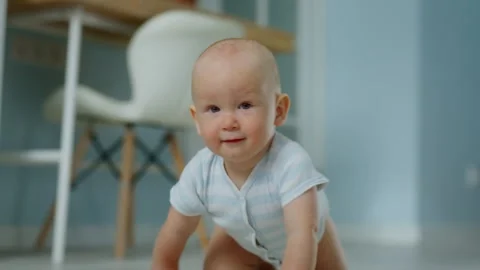 Smiling baby runs towards the camera on all fours. Child learns about the world Stock Footage 302978782