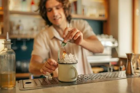 Smiling bartender making drinks behind the counter of a bar Stock Photos