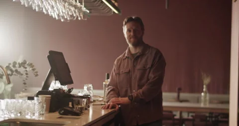 Smiling bearded bar owner standing at counter with crossed arms Stock Footage 239165884
