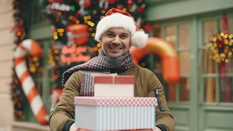 Smiling Bearded Guy in Santa Hat Standing Outside in the Decorated City Centre Stock-Footage 253003310