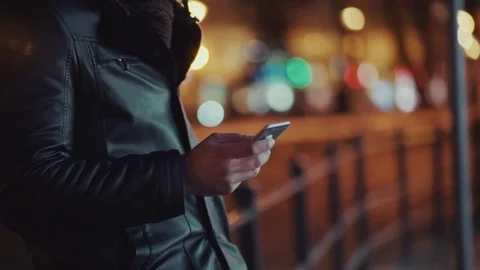 Smiling bearded man in leather jacket and stylish fur hat stands in the city Stock Footage 84652630