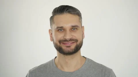 Smiling bearded man looking at camera on white background Stock Footage 147580317