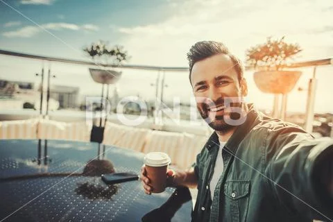 Smiling bearded man making selfie during coffee break Stock Photos