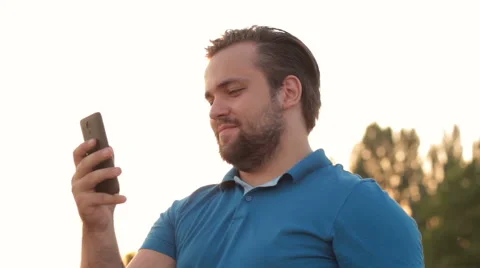 Smiling bearded man making videophone via cell Stock Footage 65505022