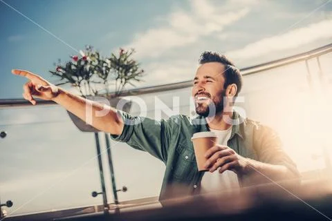 Smiling bearded man pointing finger at someone while sitting at the table Stock Photos