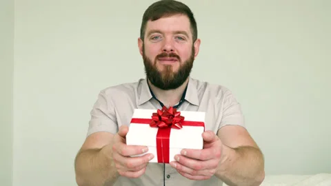Smiling bearded man presenting gift box. Stock Footage 180410300