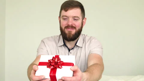 Smiling bearded man presenting gift box. Stock Footage 180411014