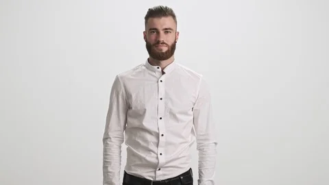 Smiling bearded man is showing thumb up isolated over white wall background Stock Footage 125320294