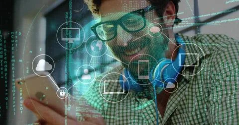 Smiling bearded man tapping smartphone screen in tech workspace, with 스톡 사진