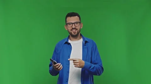 Smiling bearded Man Use Mobile Phone And Pointing To Smart Phone Screen And Stock Footage 168946896