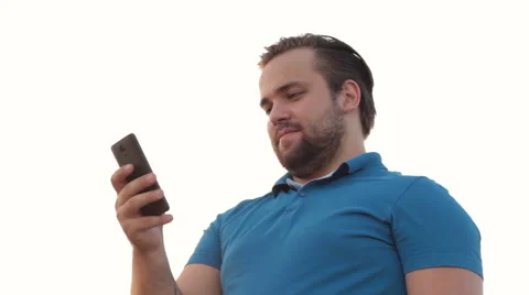 Smiling bearded man using phone 스톡 동영상 65504965