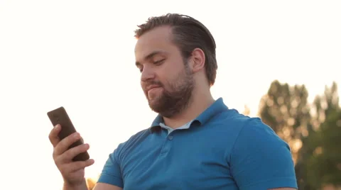 Smiling bearded man using smartphone outdoor 스톡 동영상 65504975