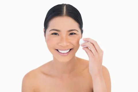 Smiling beautiful model using cotton pad on her face Stock Photos