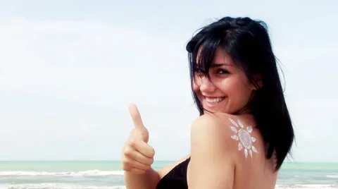 Smiling beauty on the beach with sun made of cream on shoulder Stock Footage 40493206