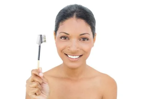 Smiling black haired model holding eyebrow brush Stock Photos