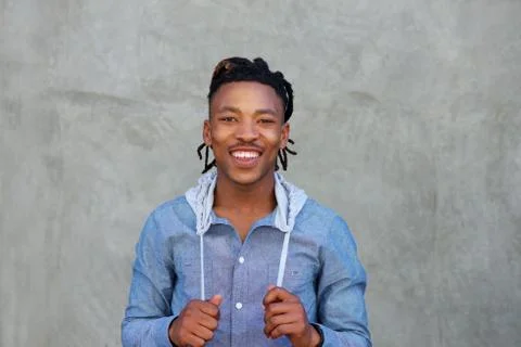 Smiling black man with dreadlocks standing against wall Stock Photos