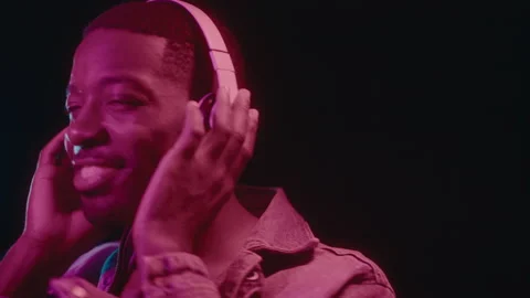 Smiling Black Man in Headphones Dancing in Neon Light Stock Footage 236684809