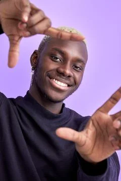 Smiling black man make frame from hands, point at camera Stock Photos