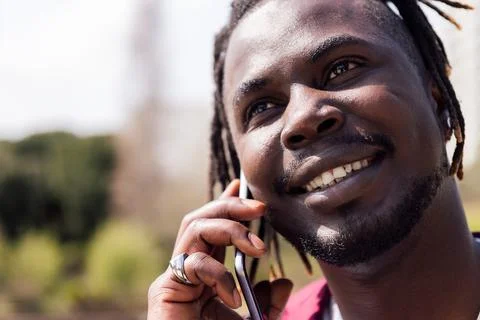 Smiling black man talking on smart phone outdoors Stock Photos