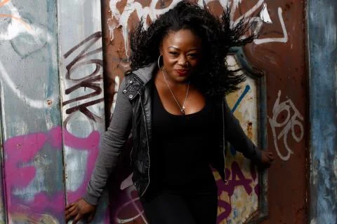 Smiling black woman posing at wall with vandals Stock Photos
