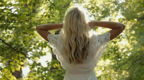 Smiling blond clothed in a dress resting in the forest Stock Footage 59321456