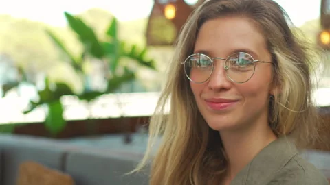 Smiling blond young female developer working on laptop at terrace cafe Video stock 282476000