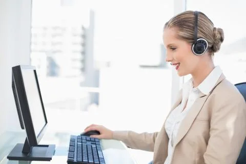 Smiling blonde call centre agent working Stock Photos