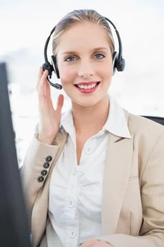 Smiling blonde call centre agent interacting with customer Stock Photos