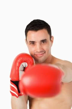 Smiling boxer attacking with his left fist Stock Photos