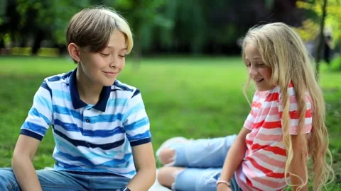 Smiling boy and girl checking smartwatch notification greeting each other 스톡 동영상 137628703