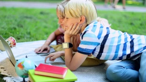 Smiling boy and girl using modern laptop in sunny park. Social networking. Learn 스톡 동영상 137328435
